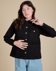 Alex is wearing a buttoned up Work Jacket in Basic Black