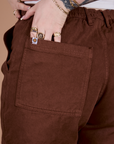 Close up of Sydney's hand in the back pocket of Classic Work Shorts in Fudgesicle Brown