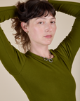 Long Sleeve Baby Tee in Summer Olive angled front view close up on Alex
