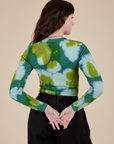 Long Sleeve Baby Tee in Green Magic Waters back view on Alex