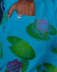 Close up of Kandia's hand in the back pocket of Paintstamped Work Pants in Lilypad