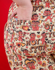 Close up of Juliet's hand in the back pocket of Work Pants in Hot Stuff Print