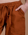 Close up of Alex's hand in the front pocket of Drop Pocket Cargo Pants in Burnt Terracotta
