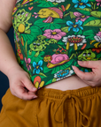 Close up of Ashley holding the hem of Pond Party Racerback Tank