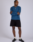 Jerrod is 6’3” and wearing M Pleated Trouser Shorts in Basic Black paired with Long Sleeve Burly Tee in French Blue