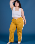Ashley is 5’7” and wearing 1XL Painted Work Pants in Mustard Yellow paired with vintage tee white Cropped Tank