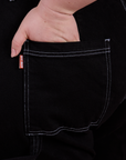Close up of Ashley's hand in the back pocket of Carpenter Jeans in Black
