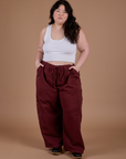 Ashley is 5'7" and wearing 1XL Drop Pocket Cargo Pants in Red Wine paired with vintage tee white Cropped Tank