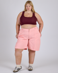 Juliet is 5’7” and wearing 2XL Longline Work Shorts in Baby Pink paired with red wine Mini Tank