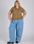 Juliet is 5’7” and wearing L Pantry Button-Up in Desert Brown paired with light wash Denim Drop Pocket Pants