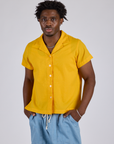 Isaac is wearing a buttoned up Pantry Button-Up in Sunshine Yellow