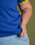 Close up of Juliet holding the bottom hem of Vintage Ringer Tee in Royal Blue
