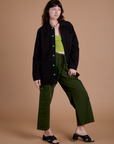 Alex is wearing Ripstop Field Coat in Basic Black paired with evergreen Drop Pocket Cargo Pants