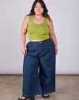 Ashley is wearing Cropped Tank Top in Gross Green paired with dark wash Indigo Wide Leg Trousers
