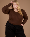 Juliet is wearing Long Sleeve Baby Tee in Fudgesicle Brown
