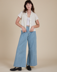 Alex is wearing Pantry Button-Up in Vintage Tee White and light wash Indigo Wide Leg Trousers