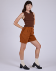 Angled front view of Pleated Trouser Shorts in Burnt Terracotta and fudgesicle brown Muscle Tee on Alex