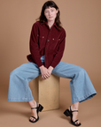 Alex is wearing Cropped Corduroy Overshirt in Red Wine and light wash Indigo Wide Leg Trousers