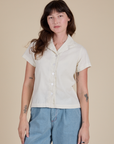 Alex is wearing a buttoned up Pantry Button-Up in Vintage Tee White