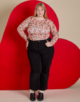 Juliet is wearing Long Sleeve Baby Tee in Hot Stuff Print tucked into black Western Pants