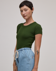 Angled front view of Baby Tee in Evergreen on Alex