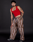 Angled front view of Striped Drop Pocket Pants in Retro Rainbow and mustang red Cropped Tank on Jesse