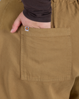 Close up of Juliet's hand in the back pocket of Longline Work Shorts in Desert Brown