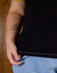 Close up of Juliet holding the bottom hem of Calypso Tee in Black Multi