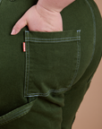 Close up of Ashley's hand in the back pocket of Carpenter Jeans in Evergreen