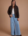 Anthony is wearing Cropped Corduroy Overshirt in Espresso Brown and light wash Indigo Wide Leg Trousers