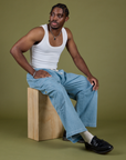 Isaac is wearing Denim Drop Pocket Pants in Light Wash and Cropped Tank in Vintage Tee White