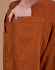 Close up of Alex's hand in the back pocket of Drop Pocket Cargo Pants in Burnt Terracotta