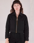 Alex is wearing a zipped up Mechanic Jacket in Basic Black