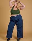 Juliet is wearing Mini Tank in Evergreen and dark wash Indigo Wide Leg Trousers