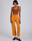 Kira is 5’10” and wearing XS Work Pants in Creamsicle Orange paired burnt terracotta Cropped Tank