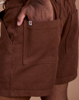 Close up of Isaac's hand in the back pocket of Classic Work Shorts in Fudgesicle Brown