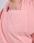 Close up of Juliet's hand in the back pocket of Longline Work Shorts in Baby Pink