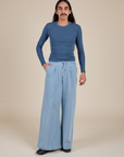 Anthony is wearing Long Sleeve Baby Tee in French Blue and light wash Indigo Wide Leg Trousers