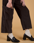 Pant leg side view close up of Corduroy Drop Pocket Cargo Pants in Espresso Brown with Alex's hand in the side pocket