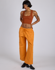 Kira is 5’10” and wearing XS Drop Pocket Cargo Pants in Creamsicle Orange paired with burnt terracotta Cropped Tank