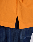 Close up of Pantry Button-Up in Creamsicle Orange side vent on Kira
