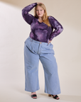 Juliet is wearing Long Sleeve Baby Tee in Dark Lavender tucked into light wash Indigo Wide Leg Trousers