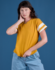 Alex is 5’8” and wearing P Painted Burly Tee in Mustard Yellow
