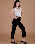 Angled front view of Carpenter Jeans in Black and Cropped Tank in Vintage Tee White on Alex