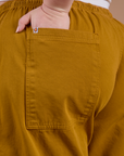 Close up of Ashley's hand in the back pocket of Drop Pocket Cargo Pants in Spicy Mustard