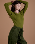 Angled front view of Gingham Long Sleeve Baby Tee in Summer Olive on Alex