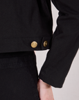 Close up of custom brass button snaps on Mechanic Jacket in Basic Black worn by Alex