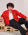 Miguel is wearing Mechanic Jacket in Mustang Red and black Western Pants