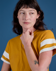Front close up of Painted Burly Tee in Mustard Yellow on Alex