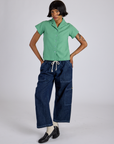 Kira is 5’10” and wearing P Pantry Button-Up in Seafoam Green paired with dark wash Denim Drop Pocket Pants